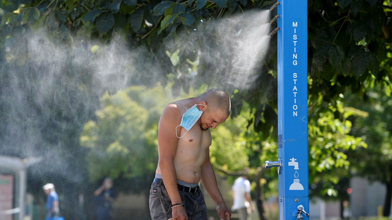 Un home es refresca en una estació de nebulització de Vancouver, a la Columbia Britànica, durant l'onada de calor al Canadà