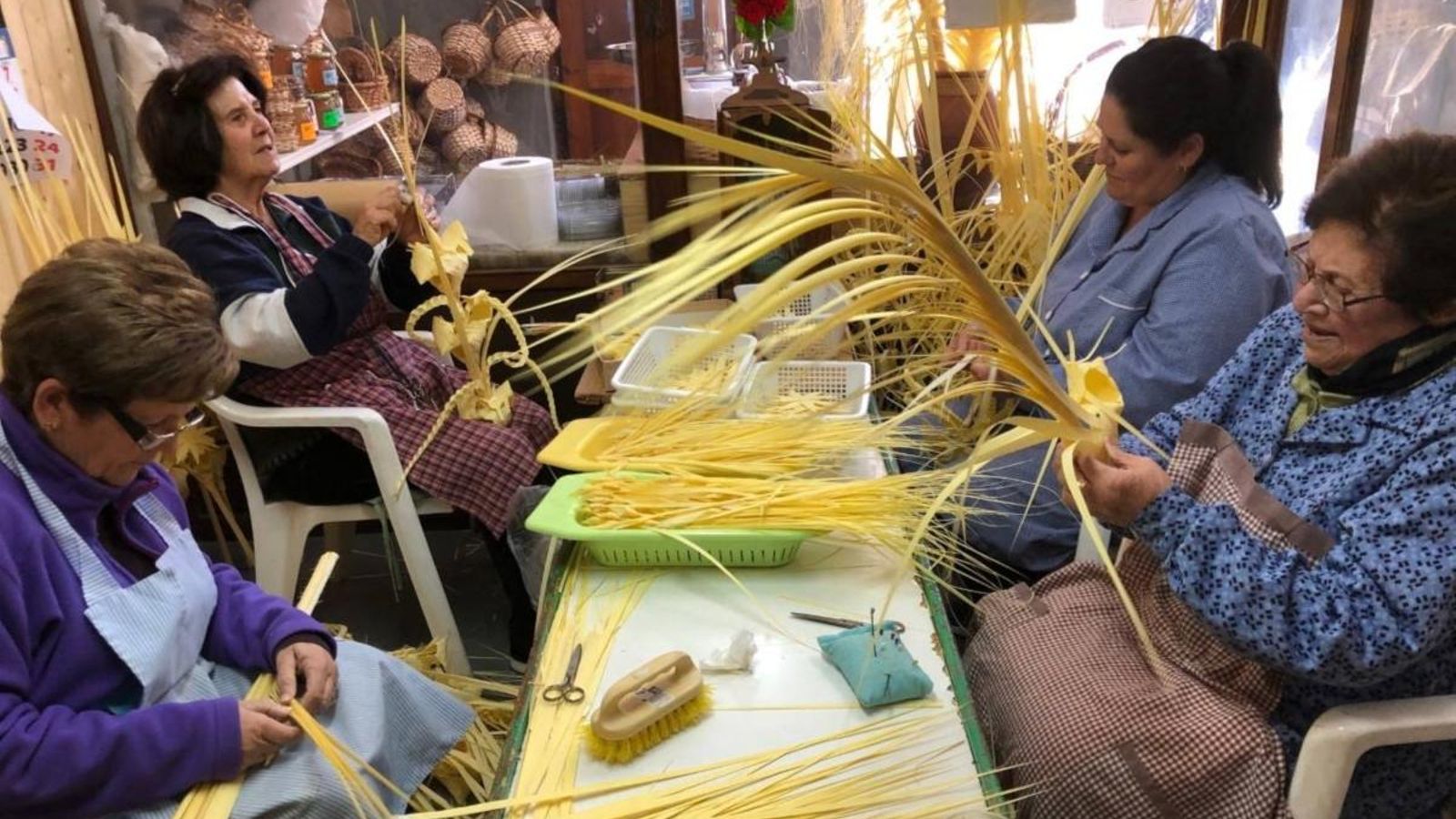 Un grup de dones treballa a un taller d'artesania de palma blanca d'Elx