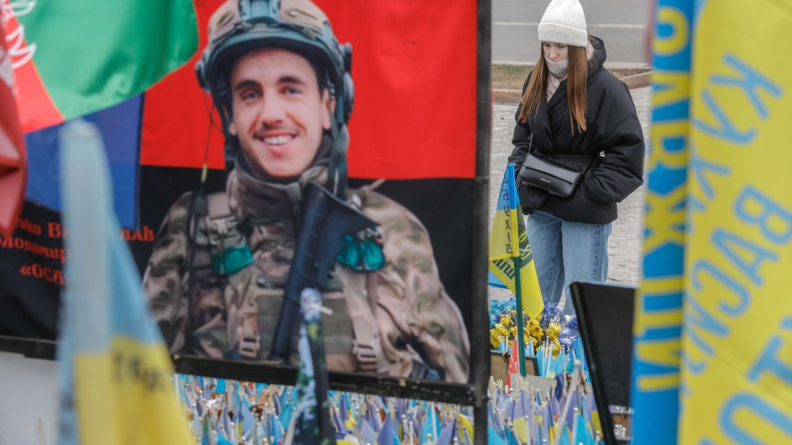 Una dona mira un monument improvisat en honor als soldats i voluntaris internacionals caiguts en la plaça de la Independència a Kíiev, Ucraïna