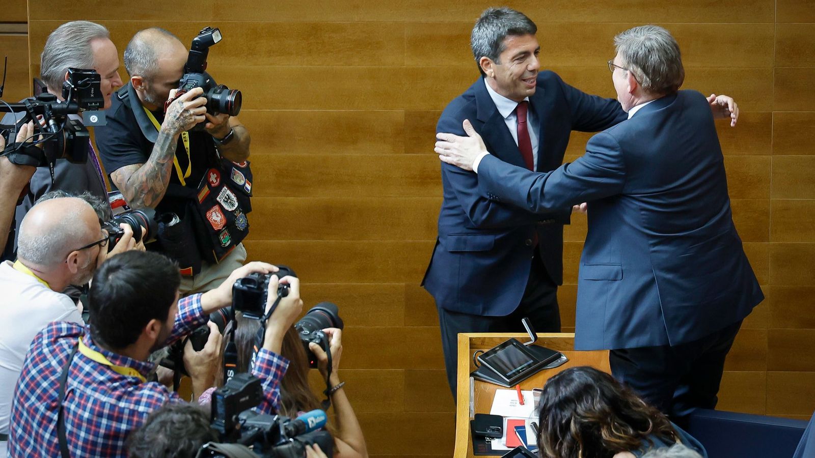 El futur president de la Generalitat, Carlos Mazón, saluda el seu homòleg en funcions, Ximo Puig, davant les càmeres dels fotògrafs i la mirada de l'exvicepresident Alberto Fabra