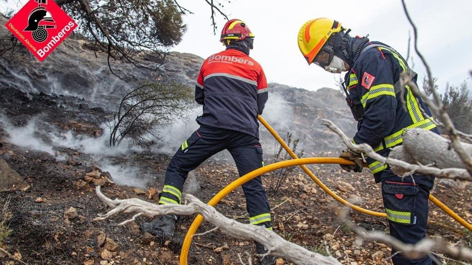 Bombers treballen en l'extinció de l'incendi forestal d'aigües
