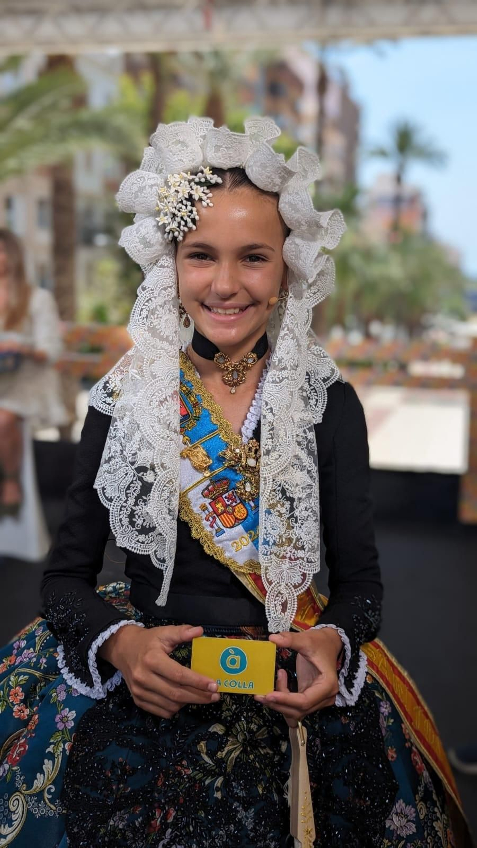Martina Lloret Rocamora, bellesa del foc infantil d'Alacant de 2024, amb el seu carnet de La Colla