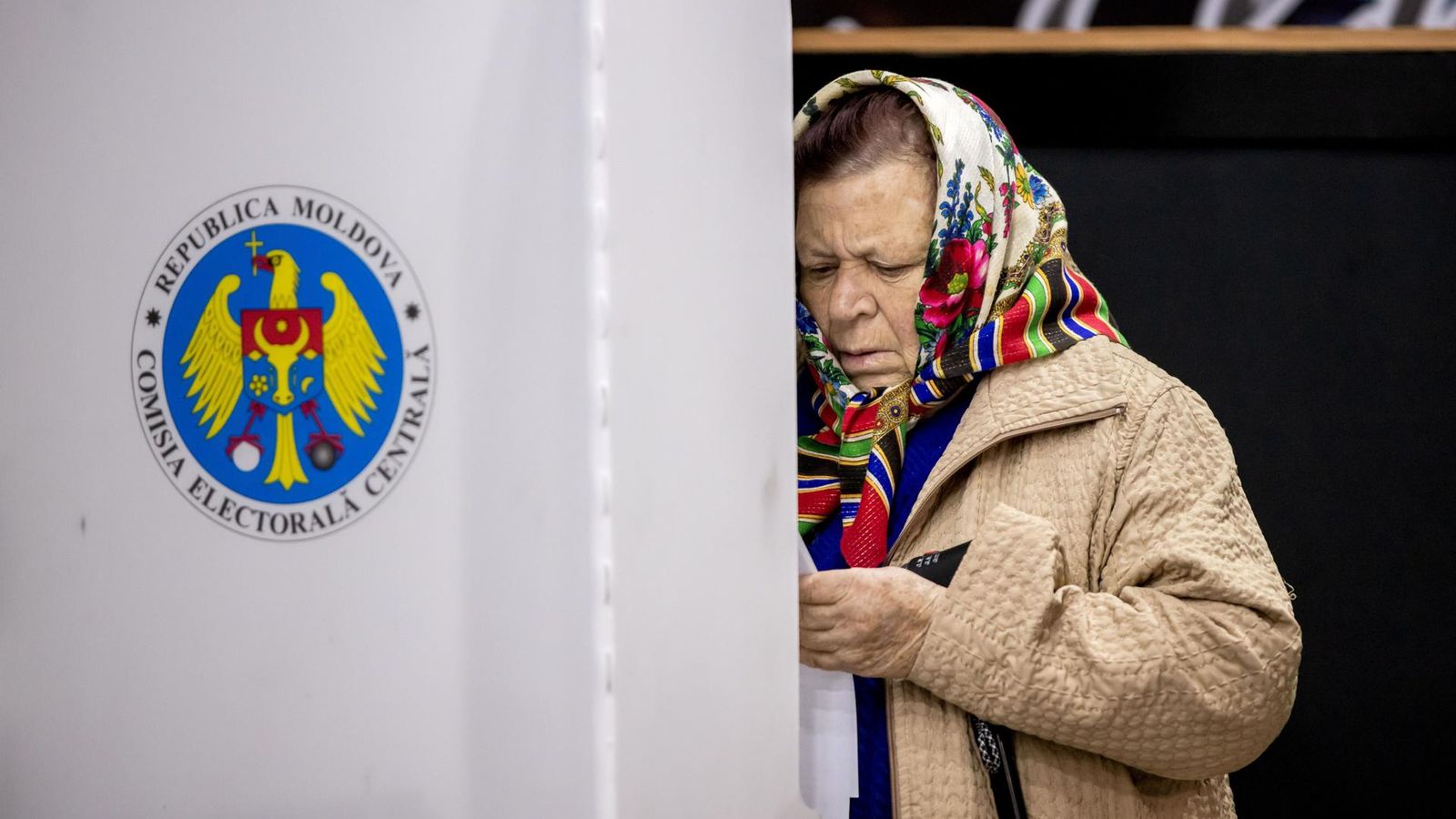 Una dona examina la seua papereta de vot en un col·legi electoral en el llogaret de Hrusevo, Moldàvia