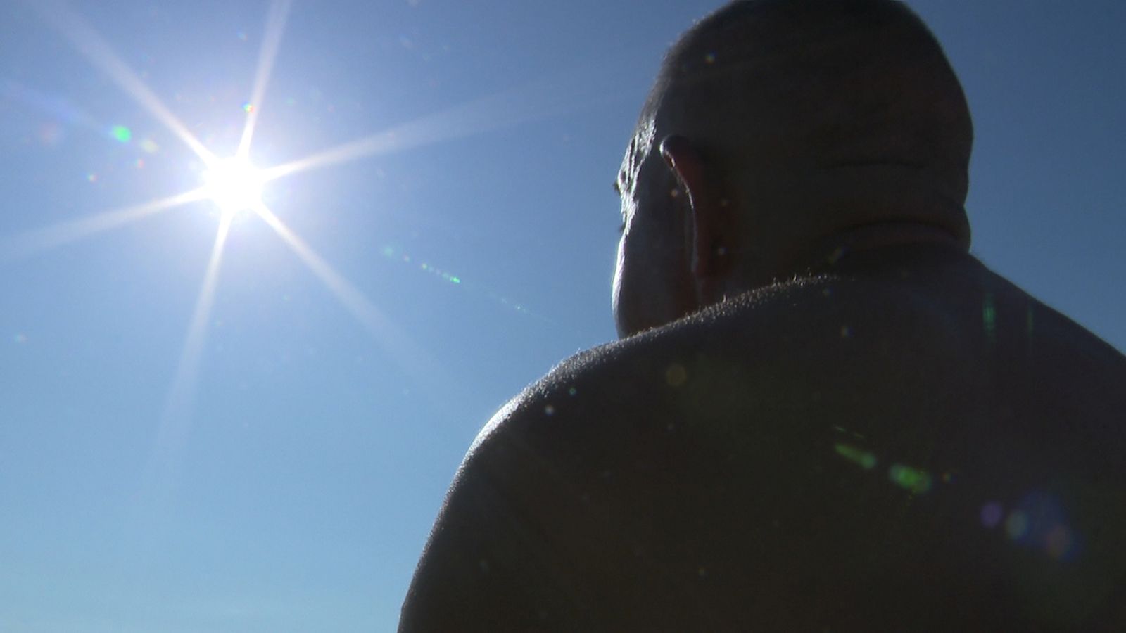 Un home pren el sol a la platja