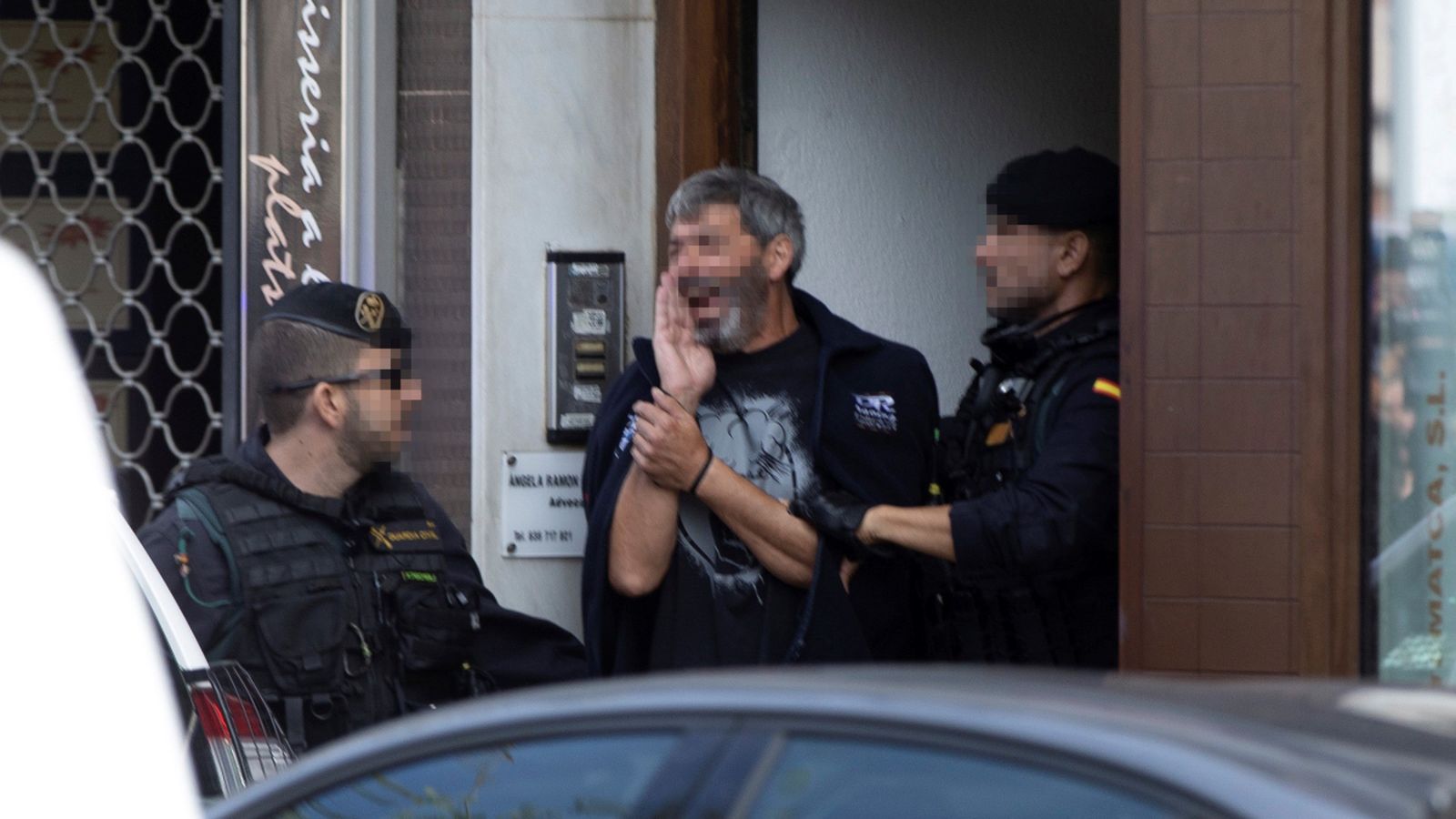 Agents de la Guàrdia Civil acompanyen a un dels detinguts durant el registre d'un domicili a Sabadell