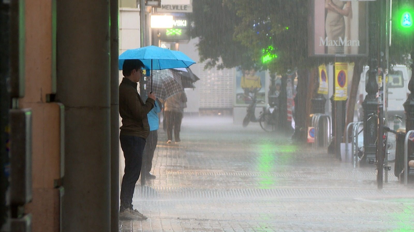 Diverses persones es protegixen de la pluja amb paraigües (arxiu)