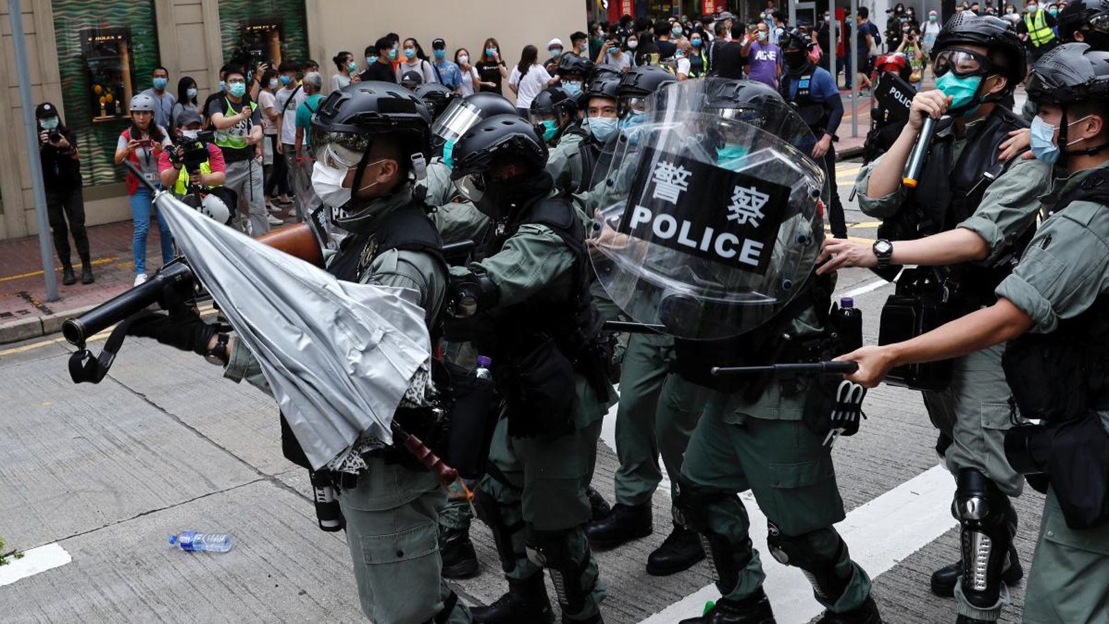 Els manifestants llancen un paraigua a la policia antiavalots