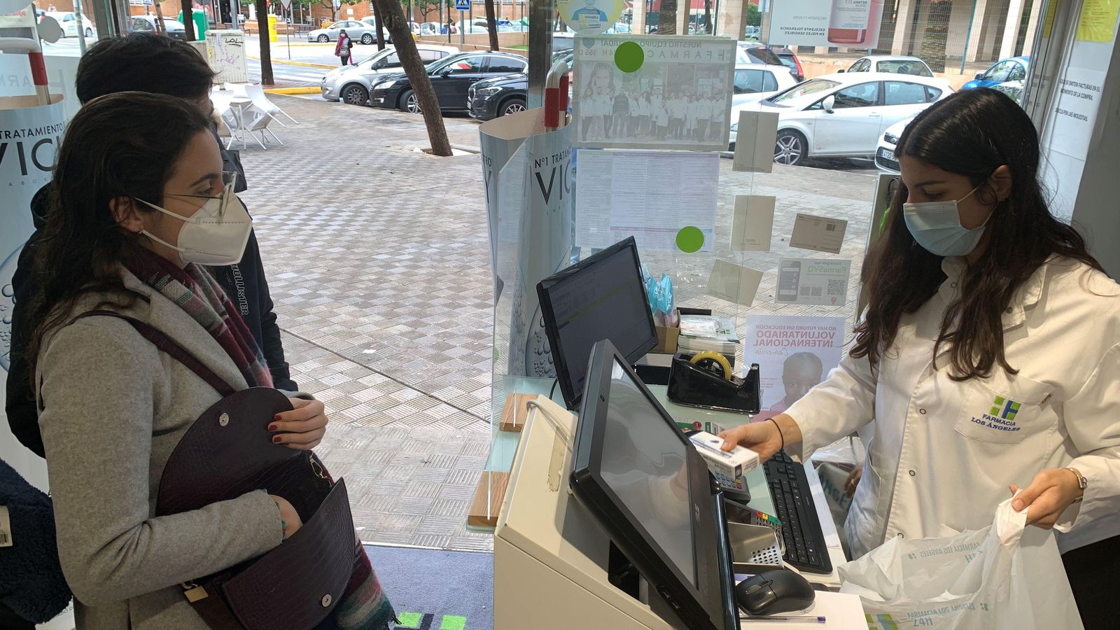 Una dona compra test d'antígens en una farmàcia