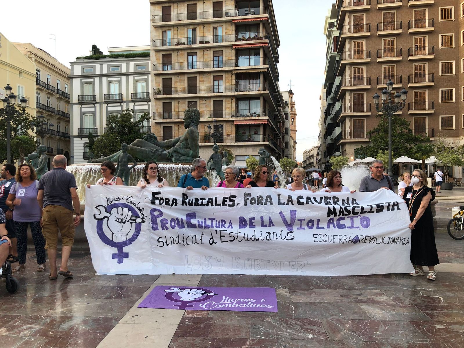 Un grup d'assistents sosté una pancarta amb un missatge contra Rubiales