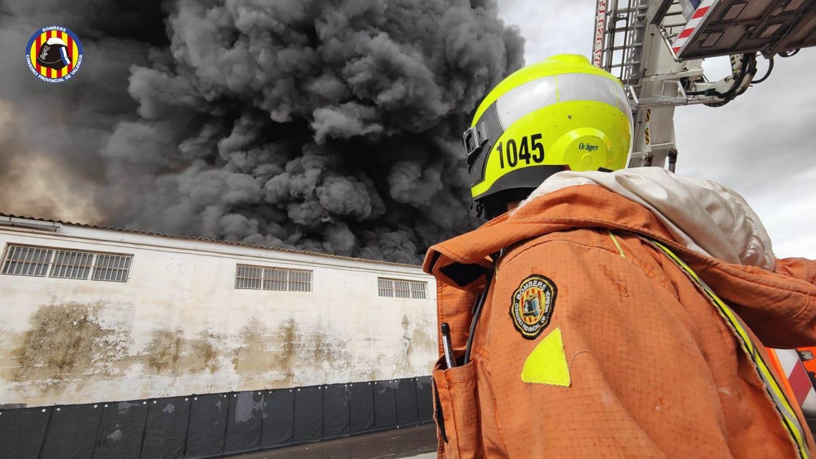 Un bomber treballant en l'incendi d'una empresa d’electrodomèstics de Sollana