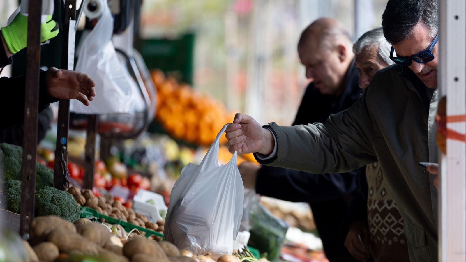 Diverses persones compren en un mercat d'aliments