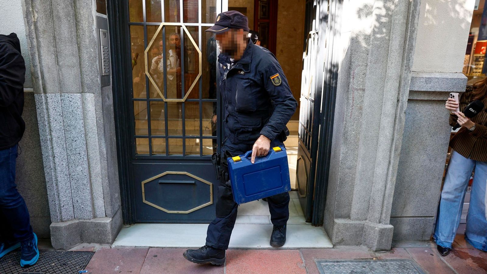 Un agent de la UDEF ix del despatx de Zapatero amb una maleta precintada