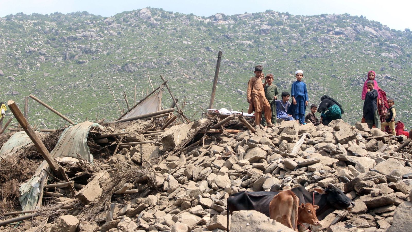 Xiquets observen les restes d’edificis danyats després del terratrémol a Kunar, l'Afganistan