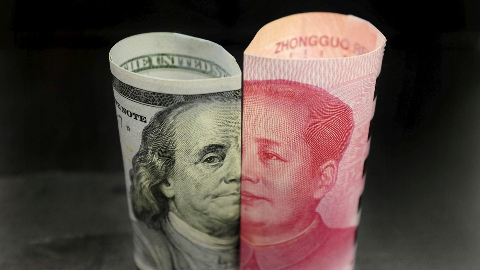 Un billet de Benjamin Franklin de 100 dòlars estadounidencs i un billet de 100 iuans xinesos amb la imatge de Mao Zedong