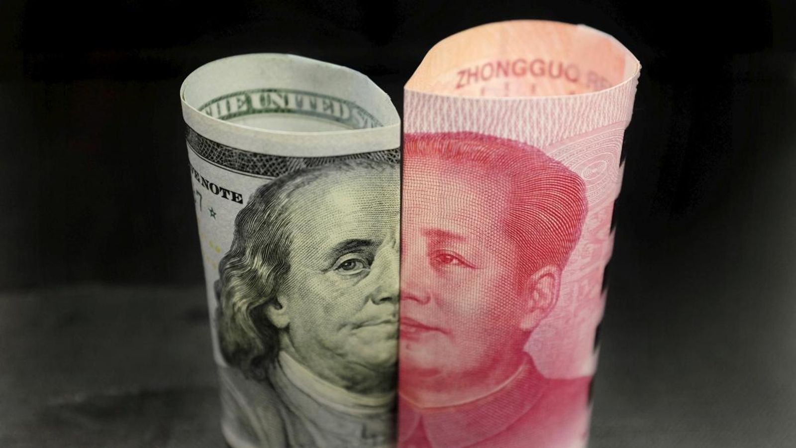 Un billet de Benjamin Franklin de 100 dòlars estadounidencs i un billet de 100 iuans xinesos amb la imatge de Mao Zedong