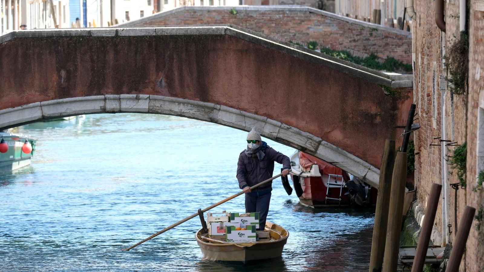 Un gondoler amb mascareta reparteix menjar pels canals de Venècia