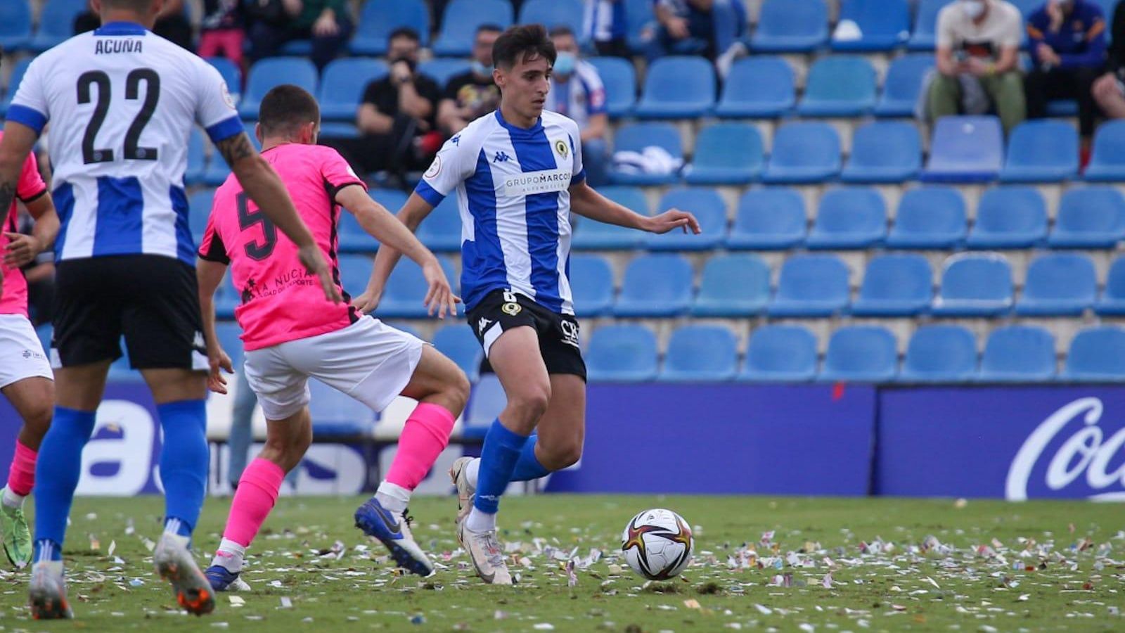Un jugador de l'Hèrcules avança amb el baló davant la pressió d'un jugador de la Nucia