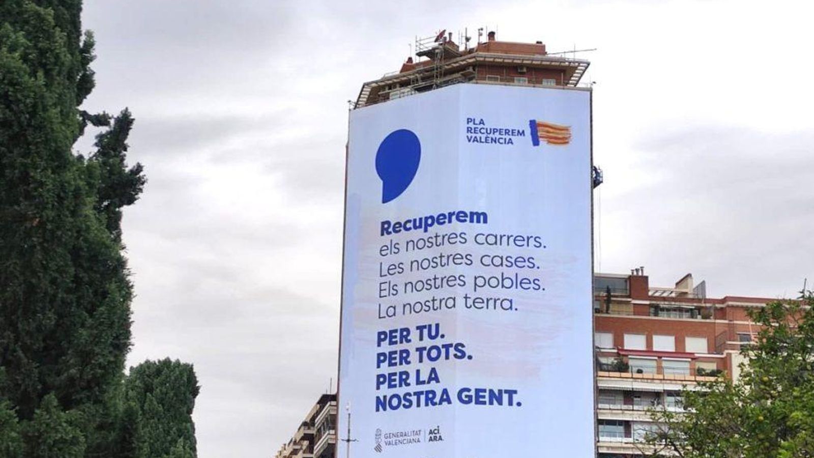 En imatge, la lona promocional de la campanya sobre un cèntric edifici de València