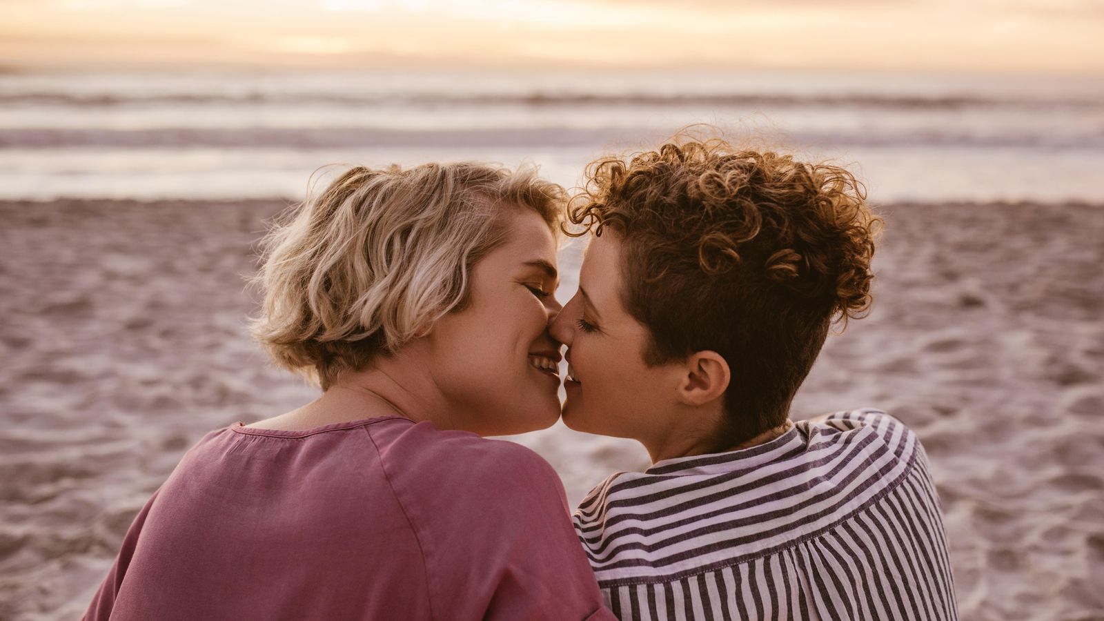 Dues dones besant-se a la platja