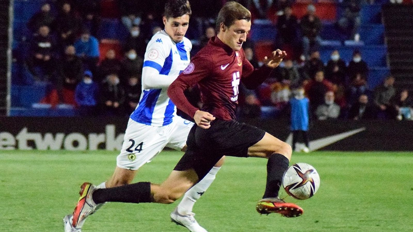 Un jugador de l'Eldenc condueix la pilota perseguit per un de l'Hèrcules