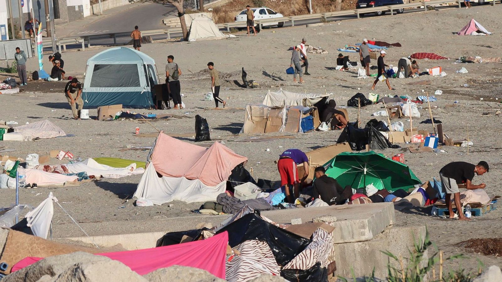 Alguns dels migrants que queden acampats en la platja del Trampolín de Ceuta, en una imatge d'este dilluns al matí