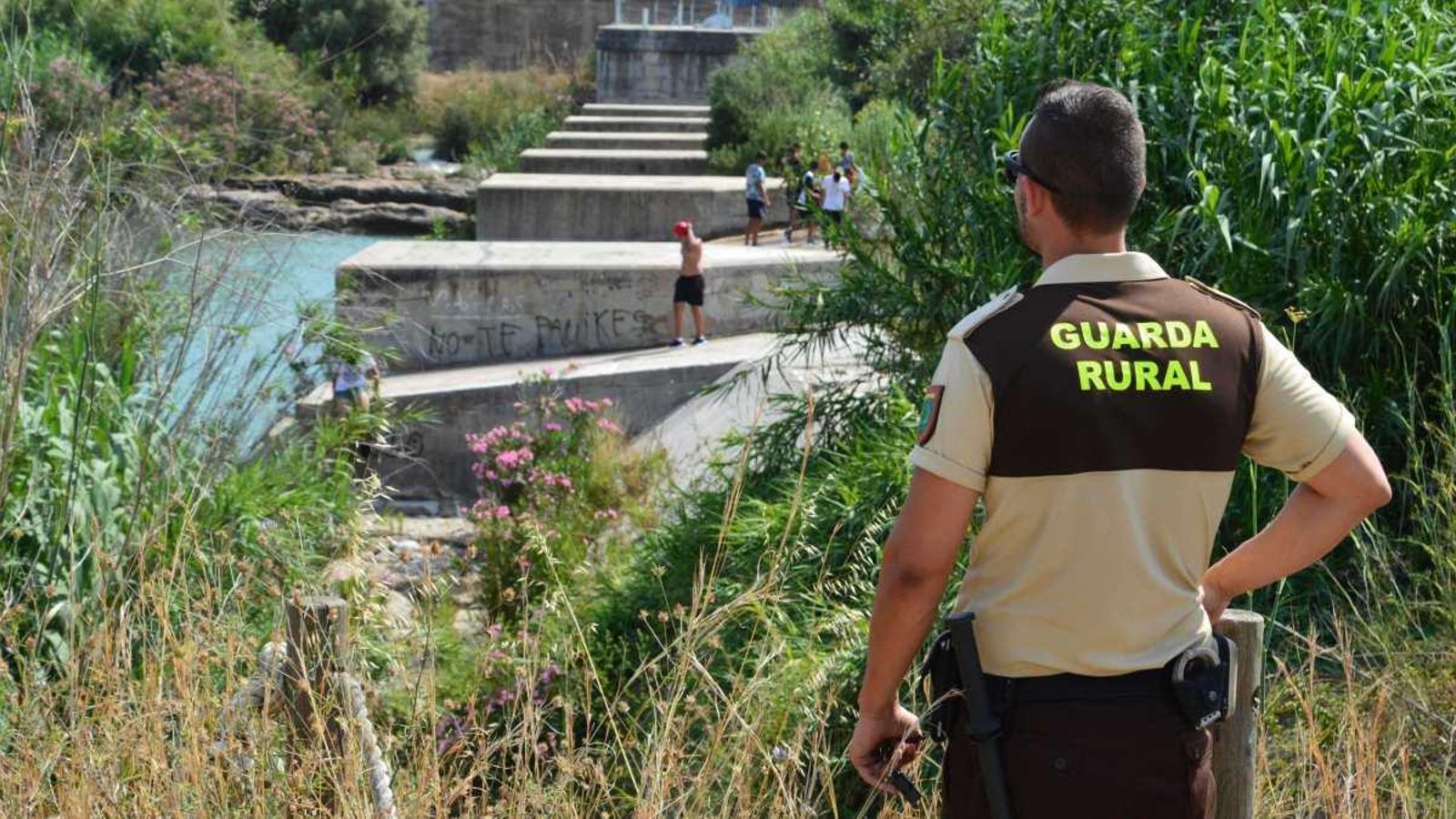 Un agent vigila els  banyistes menors a la zona dels Matxos