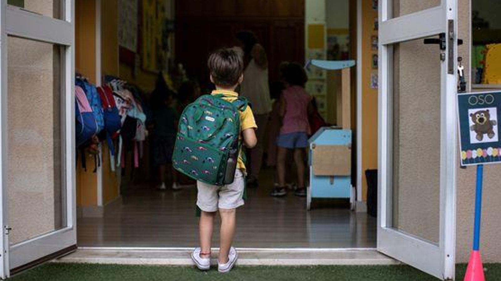 Un xiquet entra en classe en l'inici del curs escolar en una imatge d'arxiu