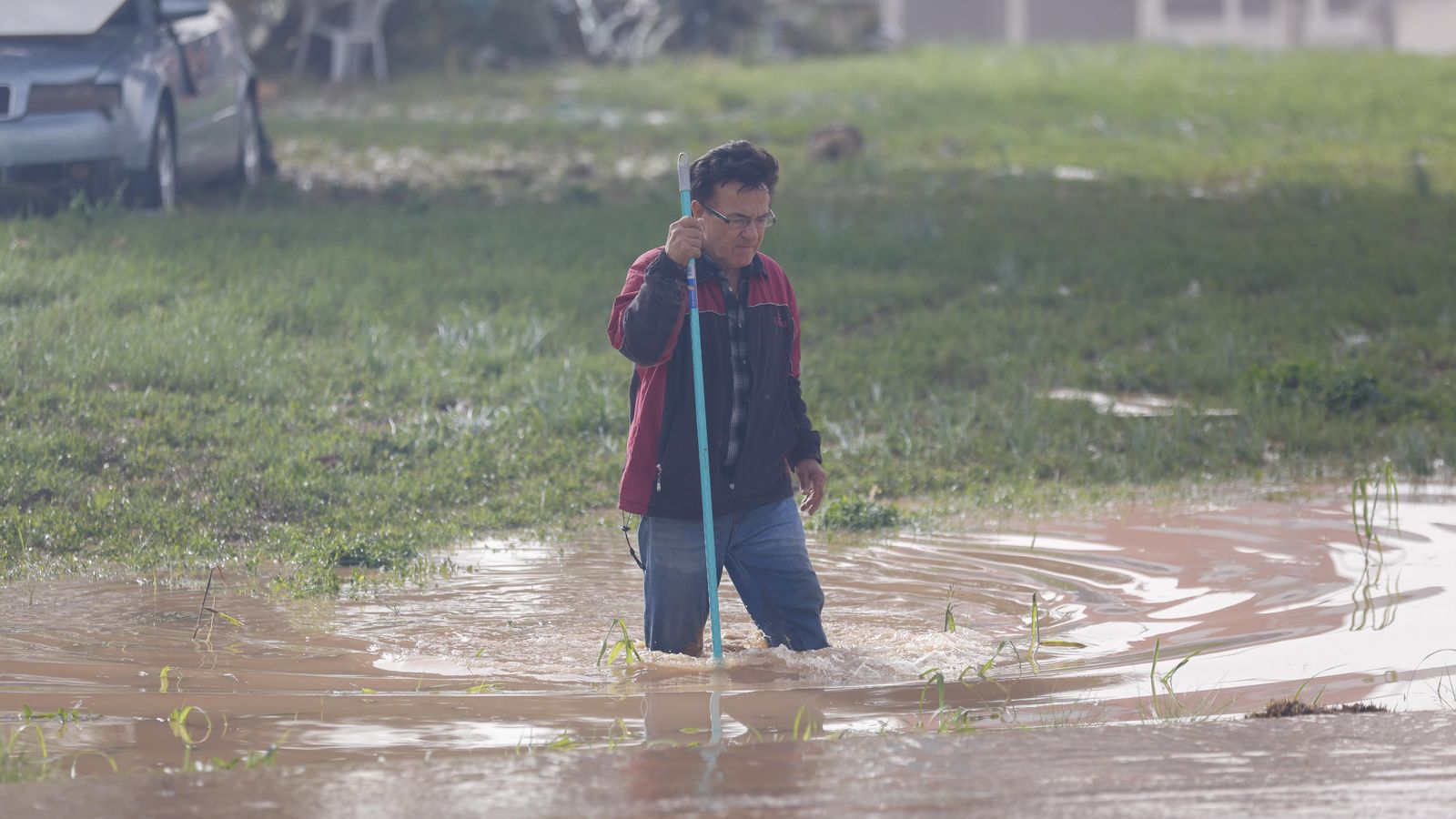 Una persona creua un carrer ple d'aigua a Sedaví
