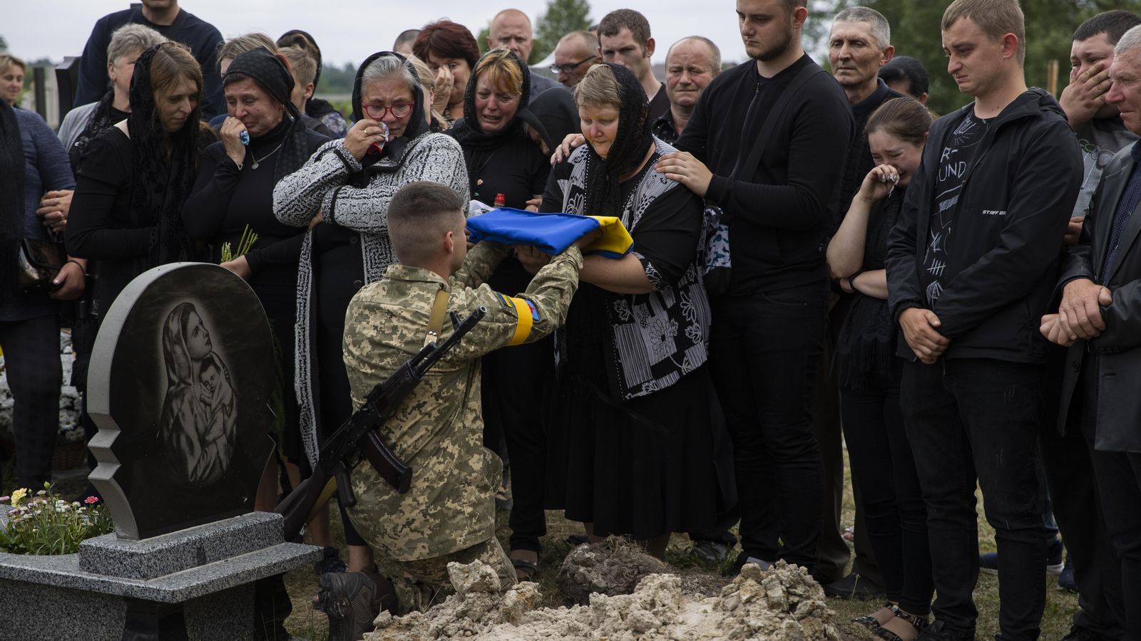 Un soldat entrega una bandera a la mare del soldat ucraïnés mort Volodimir Dmytras (28), a Novyi Vytkiv (Ucraïna).