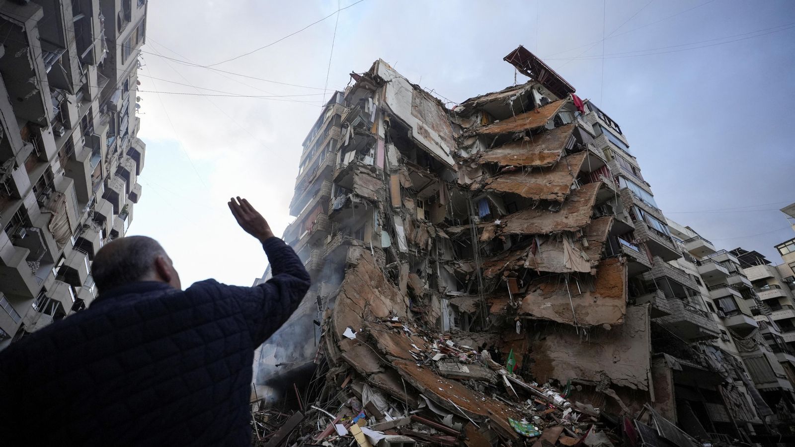 Un libanés contempla la destrucció d'un edifici residencial de Beirut atacat per l'Exèrcit d'Israel