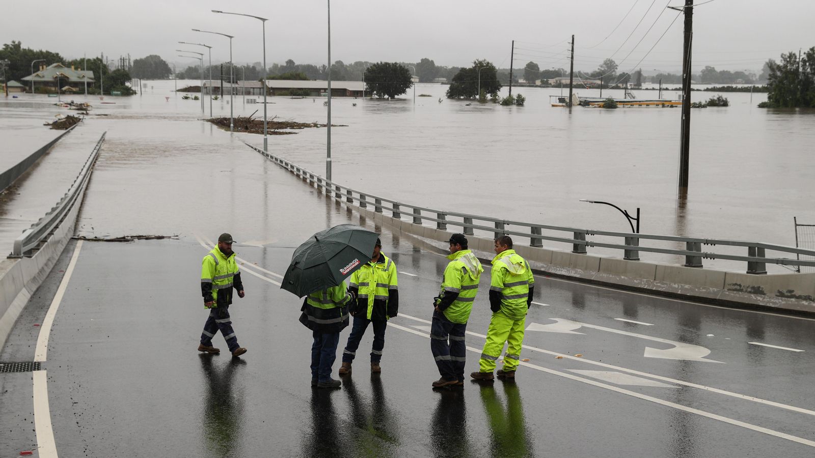 Diversos operaris avaluen l'estat d'un pont inundat en la ciutat de Windsor, a Nova Gal·les del Sud (Austràlia)