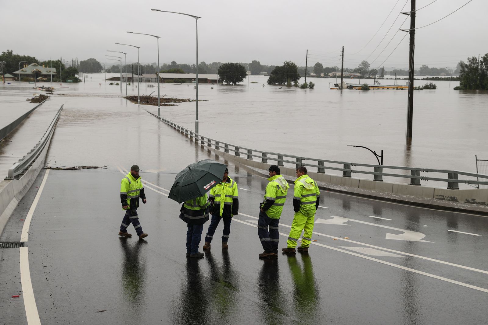 Diversos operaris avaluen l'estat d'un pont inundat en la ciutat de Windsor, a Nova Gal·les del Sud (Austràlia)