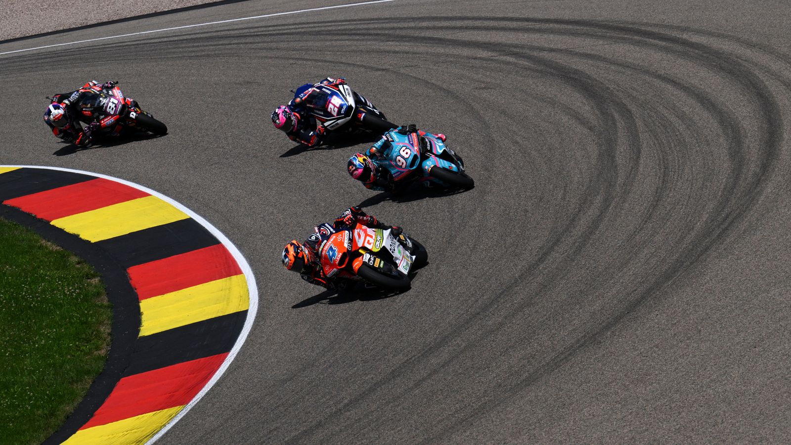 Iván Ortolá, amb la moto 4, perseguit per la moto 96 de Dani Holgado i la moto 28, d'Izan Guevara