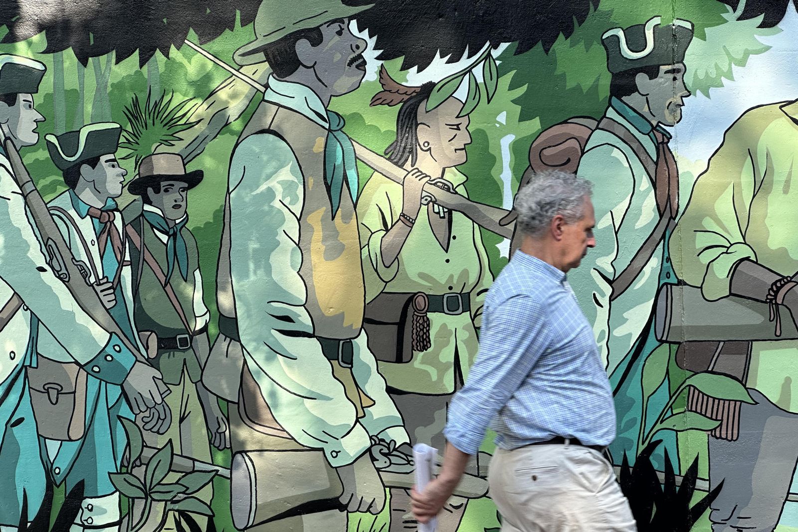Un vianant passa per davant del mural que evoca els orígen dels Estats Units