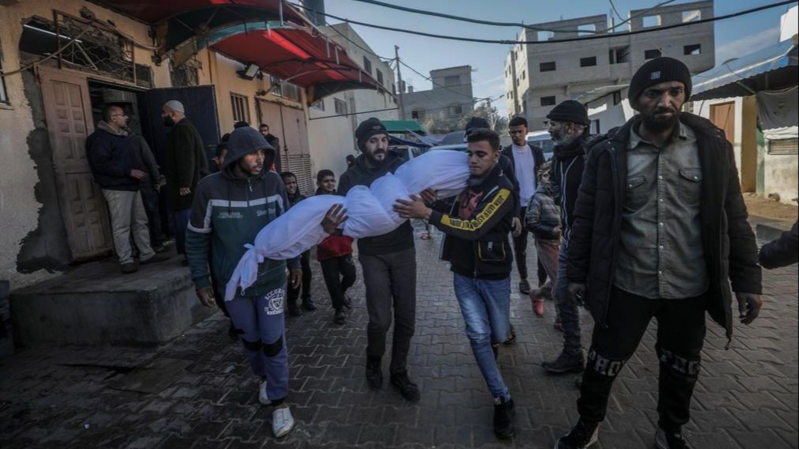 Un grup de palestins trasllada el cadàver de la dona assassinada amb el fill en un atac israelià a Deir Al Balah en les primeres hores de 2025