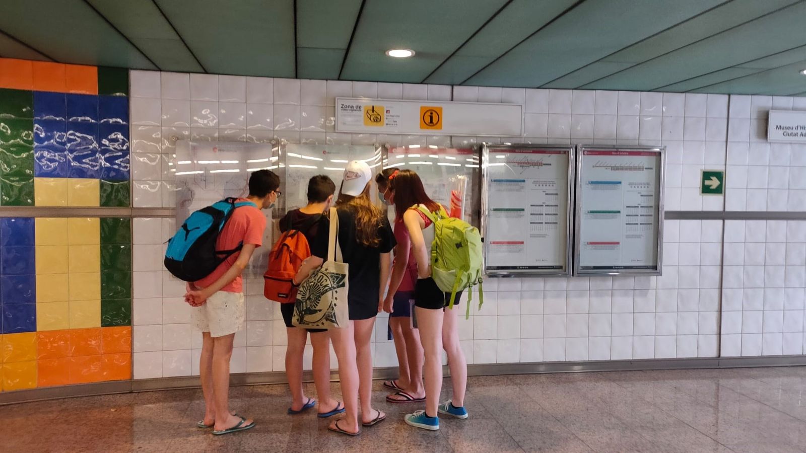 Un grup de joves consulta un panell al metro de València