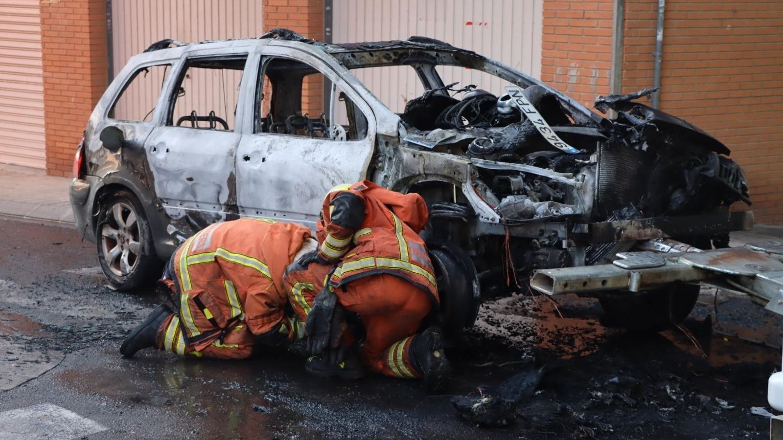 Els bombers revisen el vehicle calcinat