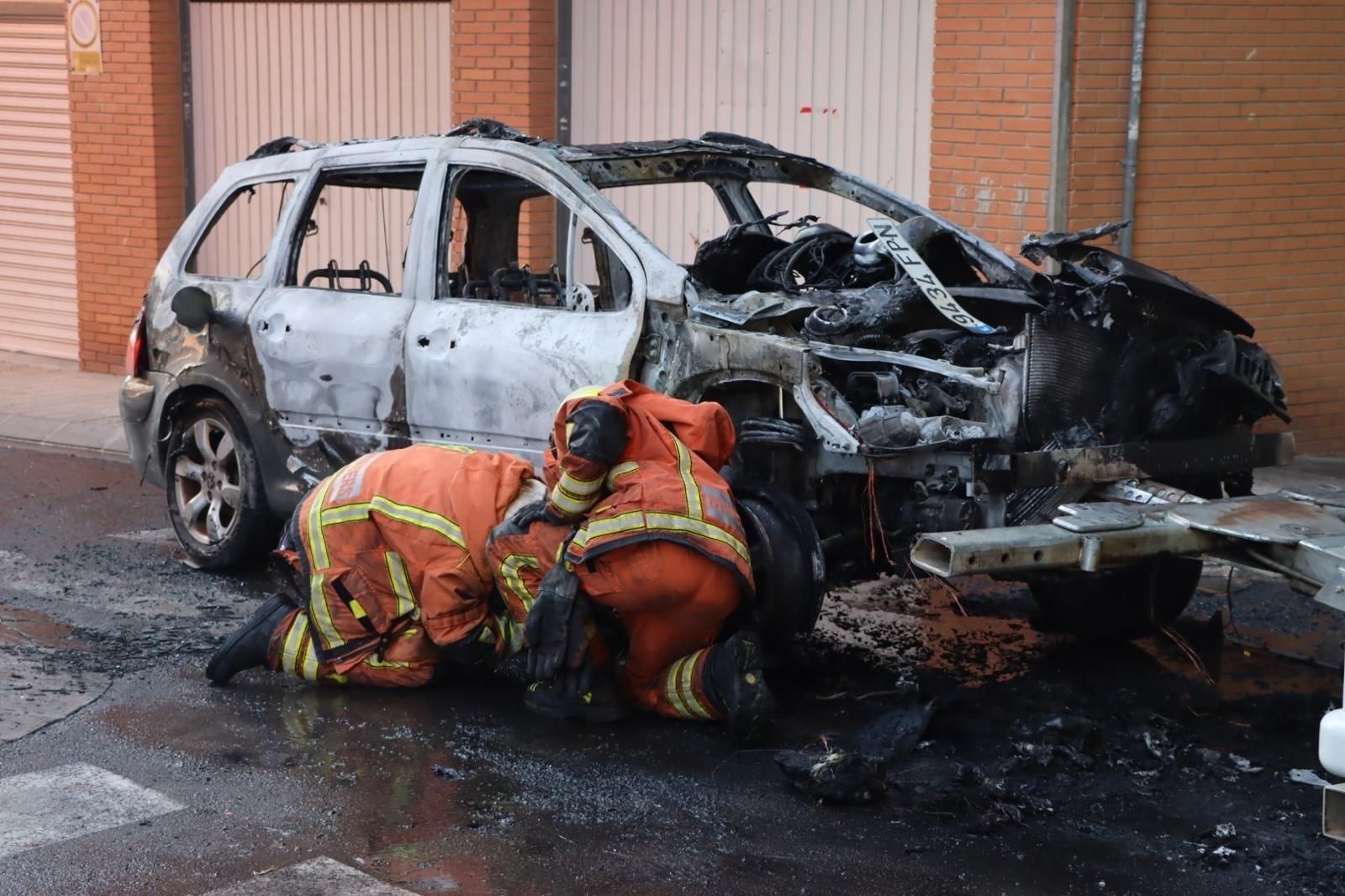 Els bombers revisen el vehicle calcinat Els bombers revisen el vehicle calcinat