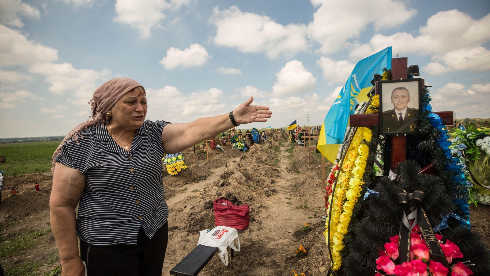 Una mare assenyala la tomba del seu fill mort en el front de batalla enterrat en l'àrea de soldats caiguts a la ciutat de Dnipro, Ucraïna.