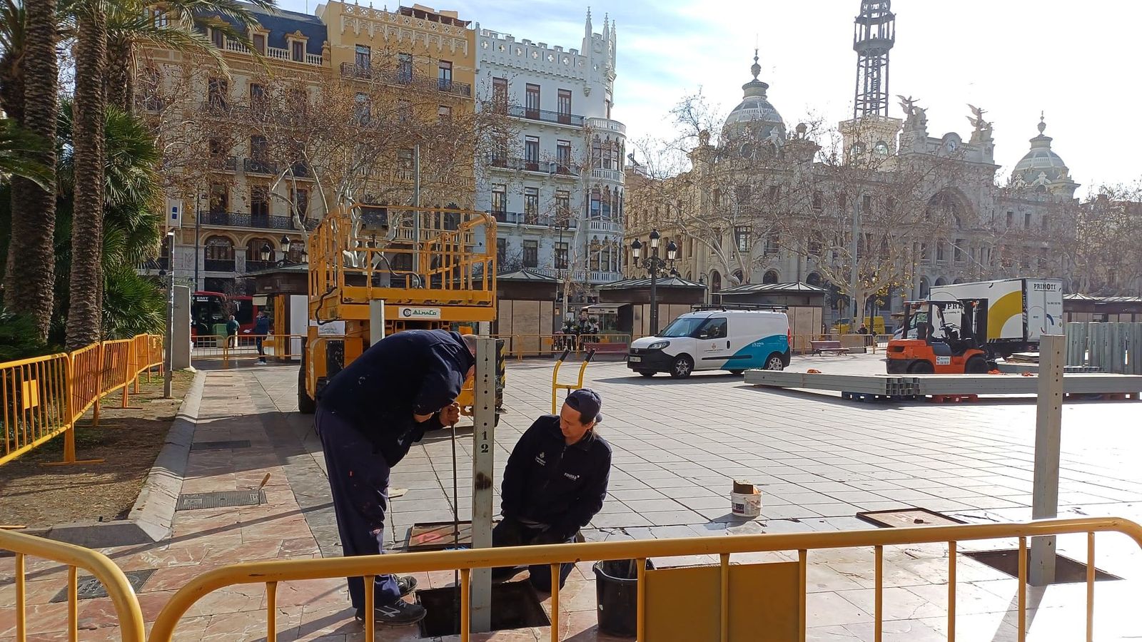 Dos operaris col·loquen els pals que subjectaran la tanca del recinte on es dispararan les mascletaes