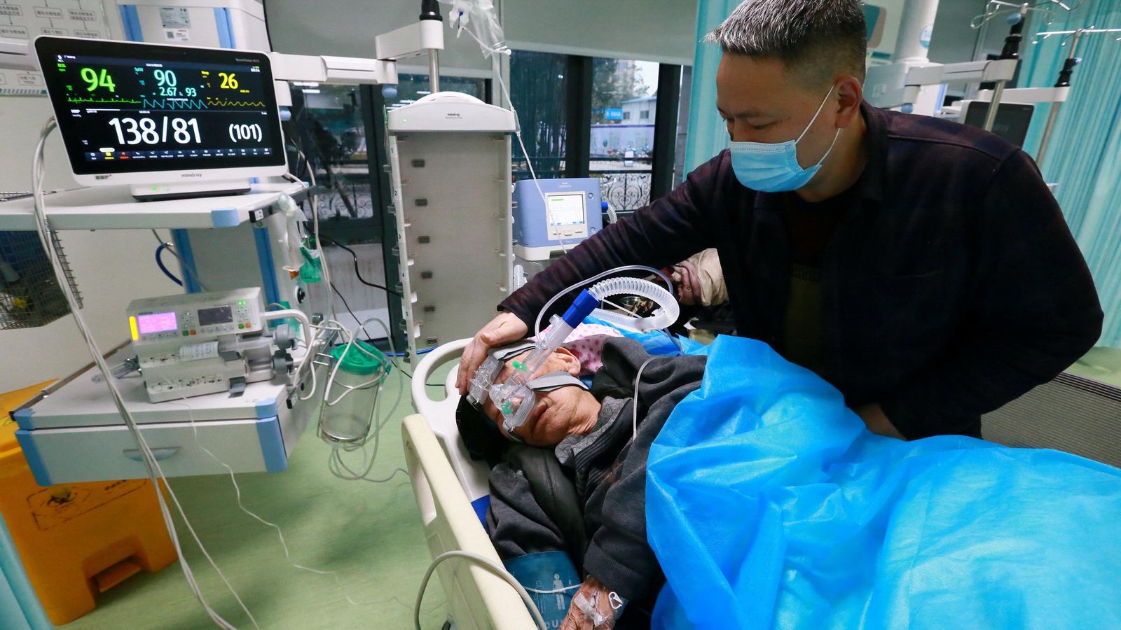 Un familiar atén un pacient amb covid a un hospital de Sichuan, a la Xina