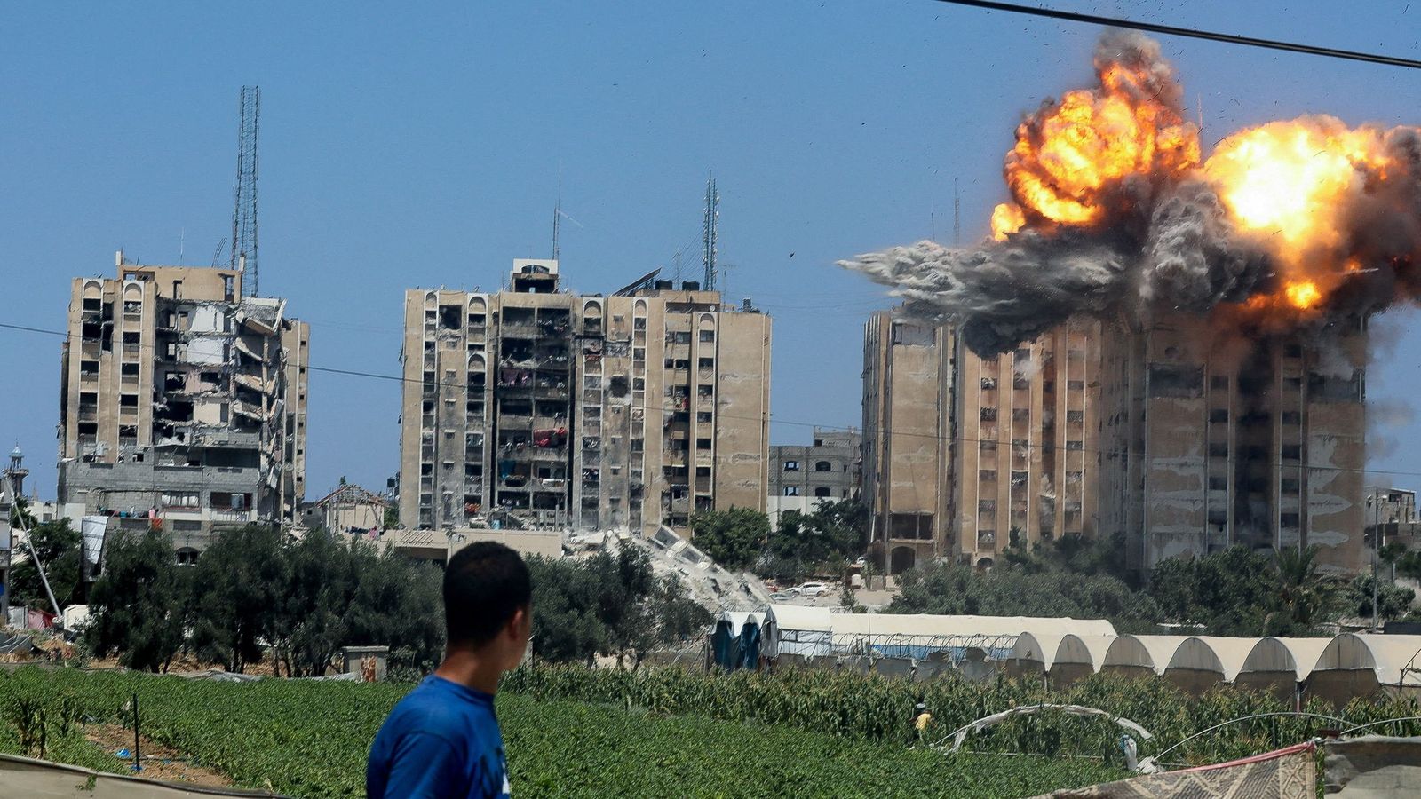Un jove contempla l'impacte d'un projectil israelià en un bloc d'habitatges del campament de refugiats de Nuseirat