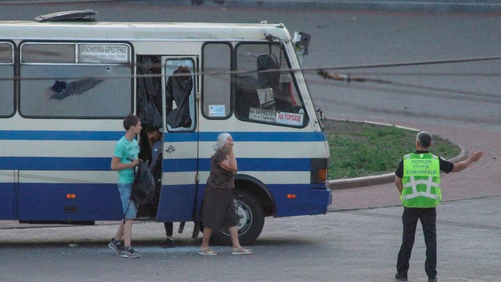 Un policia dirigeix a tres ostatges alliberats de l'autobús segrestat