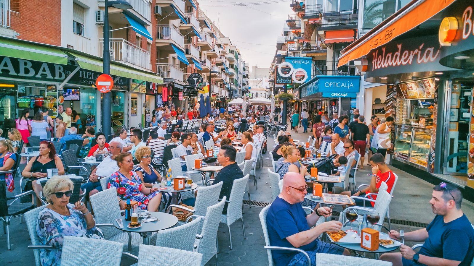 Un carrer de Benidorm amb cafeteries ple de turistes en una imatge d'arxiu