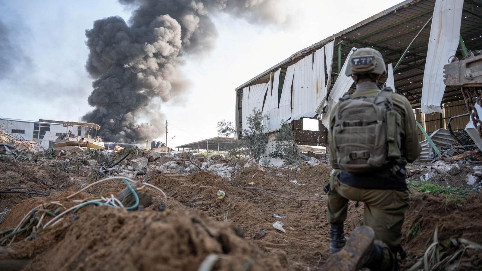 Un soldat israelià contempla una columna de fum després d'un bombardeig