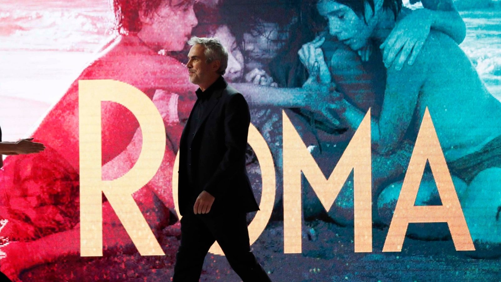 Alfonso Cuarón davant d'un cartell de 'Roma', pel·lícula amb un 90% de veus femenines