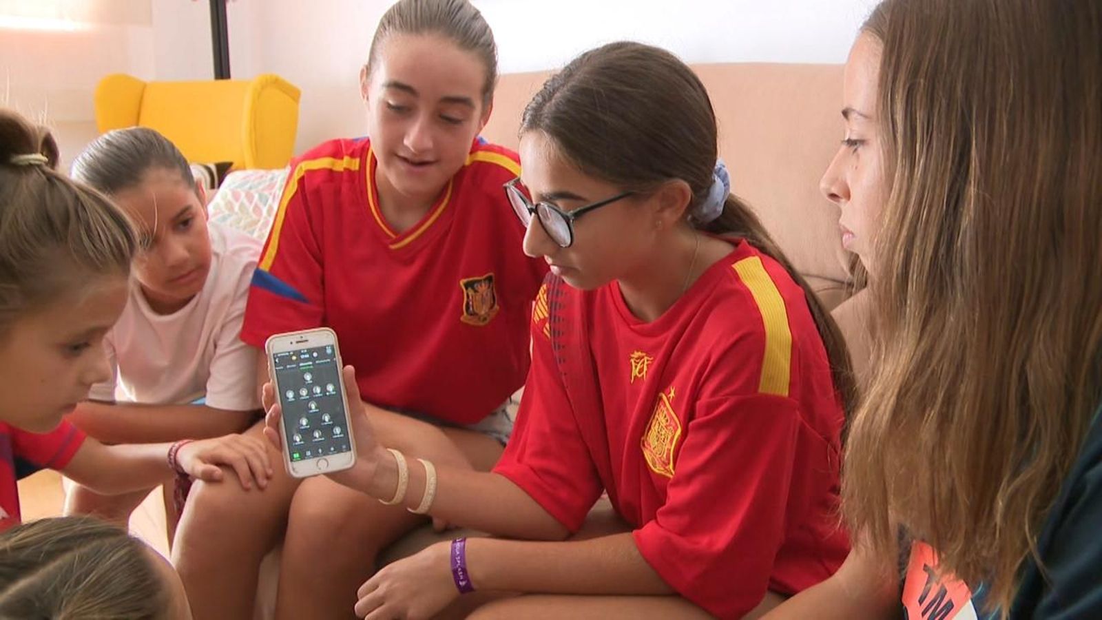 Joves aficionades de la selecció espanyola consulten l'alineació de l'equip