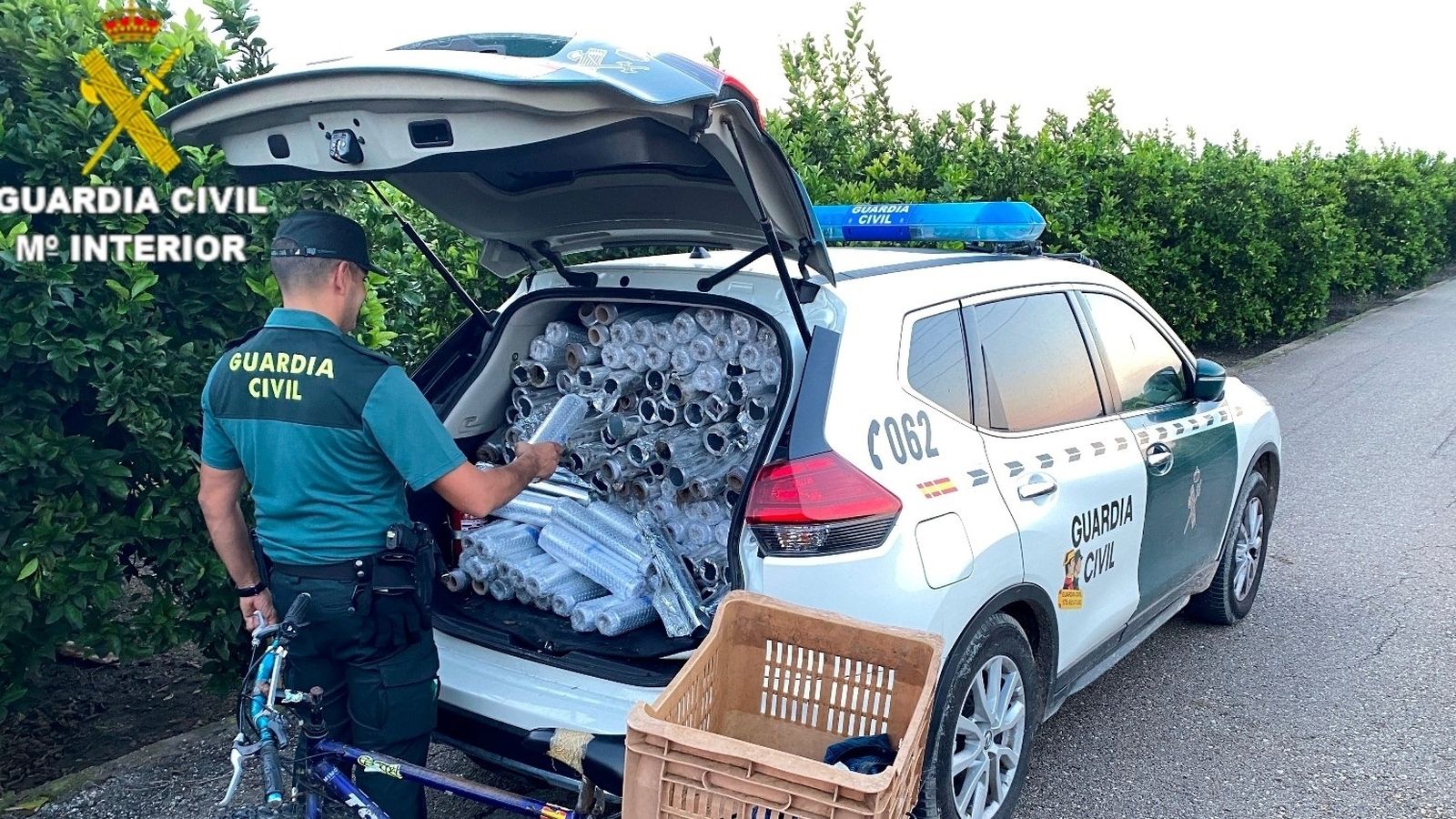 Un agent de la Guàrdia Civil carrega en el vehicle policial el material confiscat