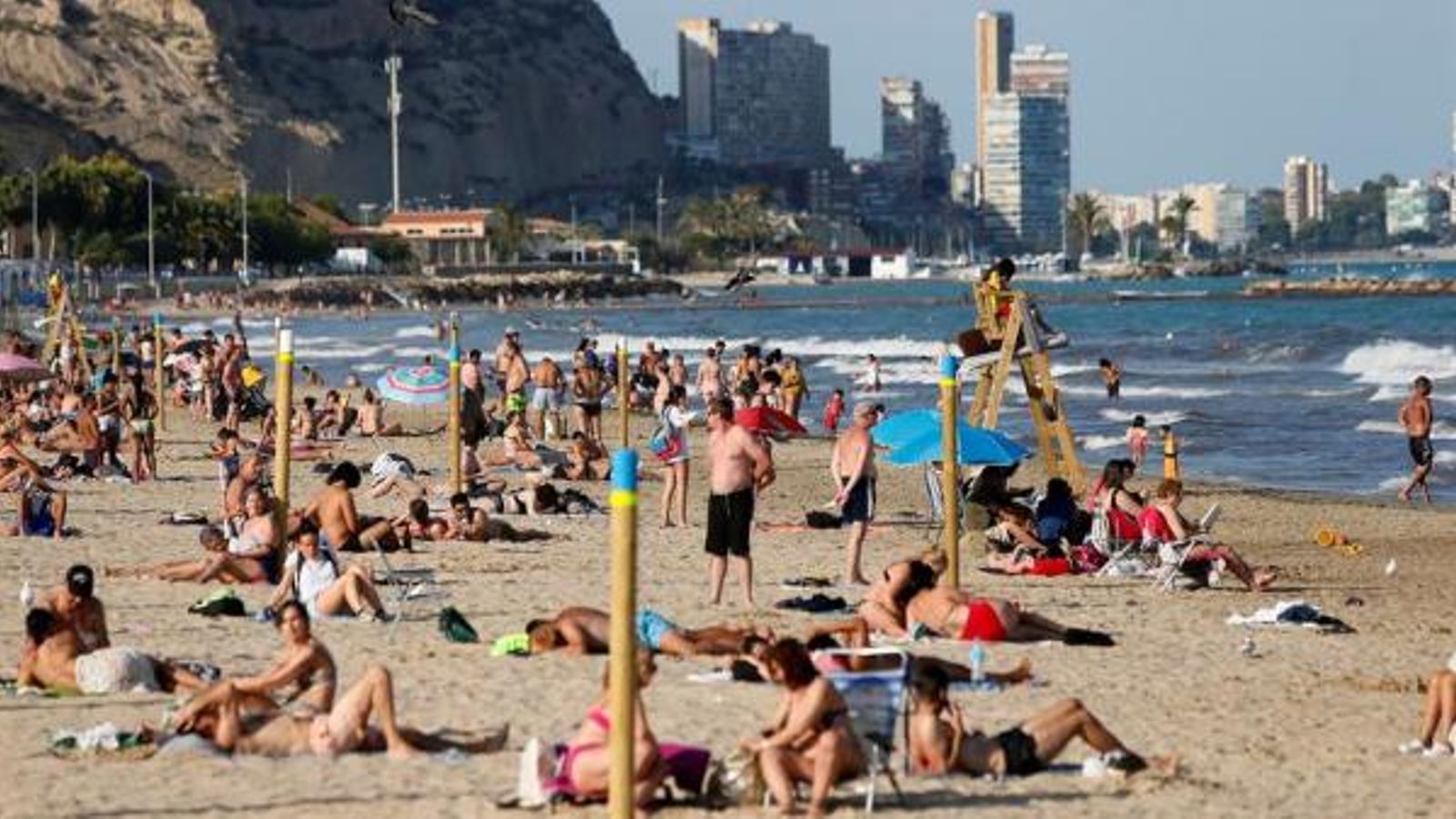 Desenes de persones gaudeixen de la 'nova normalitat' a la platga del Postiguet d'Alacant