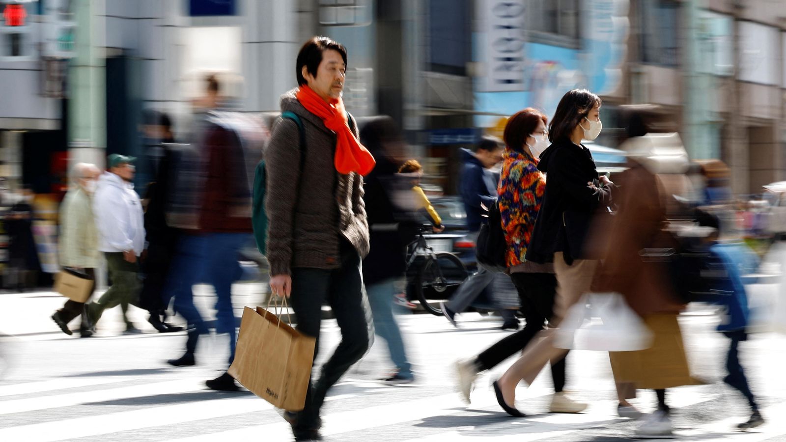 Diverses persones caminen per un carrer a Tòquio Diverses persones caminen per un carrer a Tòquio